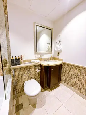 a bathroom with a toilet and a sink and a mirror at Premium1BR Retreat with Burj Khalifa View in Dubai