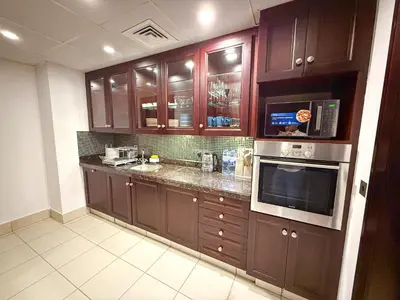 a kitchen with brown cabinets and a microwave at Premium1BR Retreat with Burj Khalifa View in Dubai