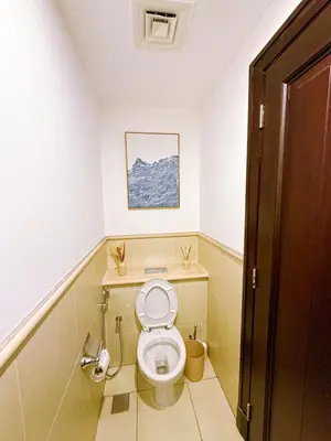 a bathroom with a toilet with a picture on the wall at Premium1BR Retreat with Burj Khalifa View in Dubai