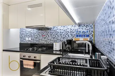a kitchen with a dish rack in the sink at Bookable 2 bed Damac Aykon City with Balcony & Pool access in Dubai
