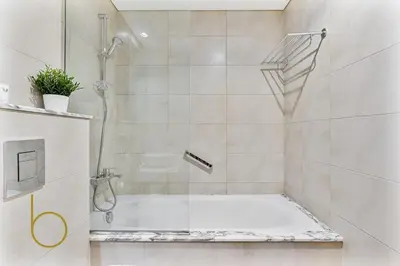 a bathroom with a shower and a bath tub at Bookable 2 bed Damac Aykon City with Balcony & Pool access in Dubai