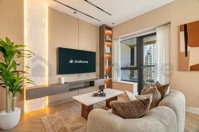 a living room with a television on a wall at Burj Khalifa View - New Furnished Unit in Downtown in Dubai