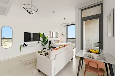 a white living room with a couch and a table at FIRST CLASS Studio Cozy Comfort in Dubai