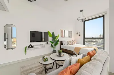 a white living room with a couch and a bed at FIRST CLASS Studio Cozy Comfort in Dubai