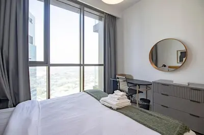 a bedroom with a bed and a desk and a mirror at Downtown Views 2BR-Direct Dubai Mall Connection in Dubai