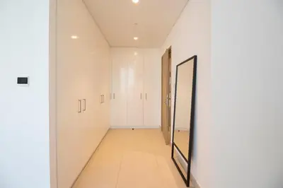 a hallway with white wardrobes and a mirror at Downtown Views 2BR-Direct Dubai Mall Connection in Dubai