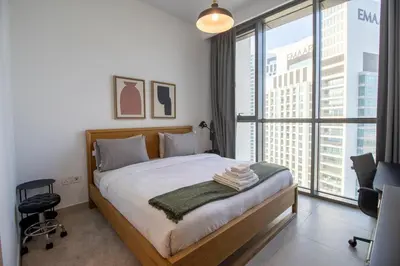 a bedroom with a bed and a large window at Downtown Views 2BR-Direct Dubai Mall Connection in Dubai