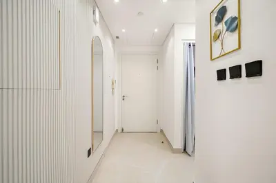 a hallway with white walls and a hallway with a door at FIRST CLASS 2BR Modern Comfort in the City in Dubai