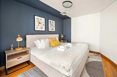 a bedroom with a large bed and a blue wall at Silkhaus Comfy Studio in Sky Gardens with DIFC Views in Dubai