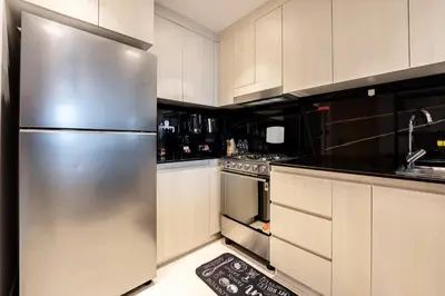 a kitchen with a stainless steel refrigerator and white cabinets at TRPS - Binghatti Jasmine, JVC - Pool View, Fully Furnished, Prime JVC Location in Dubai