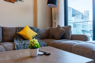 a living room with a couch and a table at TRPS - Binghatti Jasmine, JVC - Pool View, Fully Furnished, Prime JVC Location in Dubai