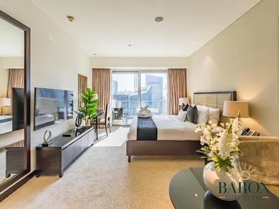 a hotel room with a bed and a television at The Muse in Dubai
