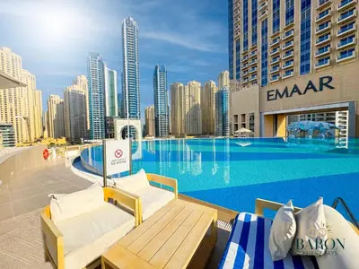 a swimming pool with two chaise lounges next to a city at The Muse in Dubai