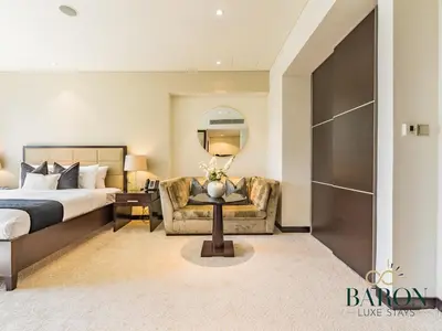 a bedroom with a bed and a couch and a chair at The Muse in Dubai