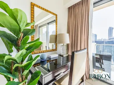 a living room with a mirror and a desk and a plant at The Muse in Dubai