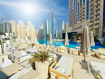 a resort with a pool and chairs and buildings at The Muse in Dubai