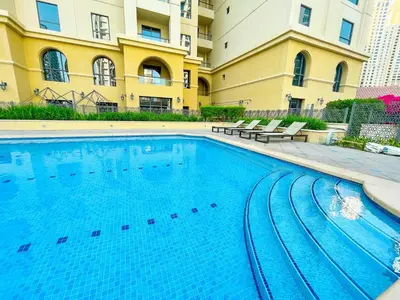 a large swimming pool in front of a building at Happy Season - Large Terrace- Panoramic View - 2BR JBR Pool Beach in Dubai