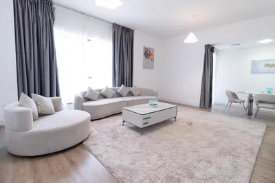 a living room with two couches and a table at Happy Season - Large Terrace- Panoramic View - 2BR JBR Pool Beach in Dubai