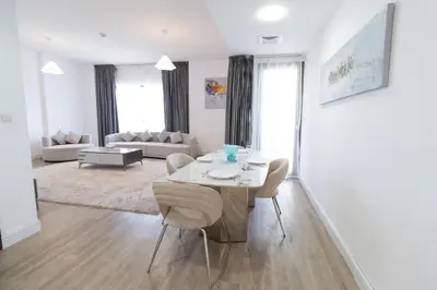 a white living room with a table and chairs at Happy Season - Large Terrace- Panoramic View - 2BR JBR Pool Beach in Dubai