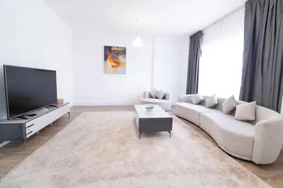 a living room with a couch and a tv at Happy Season - Large Terrace- Panoramic View - 2BR JBR Pool Beach in Dubai