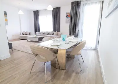 a living room with a white table and chairs at Happy Season - Large Terrace- Panoramic View - 2BR JBR Pool Beach in Dubai