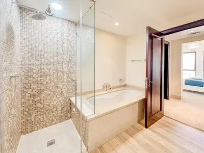 a bathroom with a tub and a glass shower at Royal Escape Burj Khalifa View 2BR in Downtown Dubai in Dubai