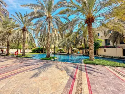 a resort with palm trees and a swimming pool at Royal Escape Burj Khalifa View 2BR in Downtown Dubai in Dubai