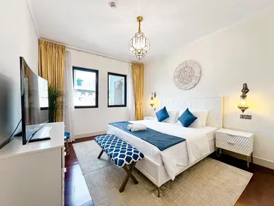 a bedroom with a white bed and a television at Royal Escape Burj Khalifa View 2BR in Downtown Dubai in Dubai