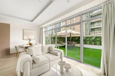 a living room with a white couch and a table at FIRST CLASS 2BR Luxury Facing Burj Khalifa in Dubai