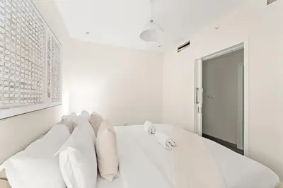 a white bedroom with a bed with white pillows at FIRST CLASS 2BR Luxury Facing Burj Khalifa in Dubai