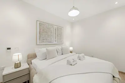 a white bedroom with a large bed with two pillows at FIRST CLASS 2BR Luxury Facing Burj Khalifa in Dubai