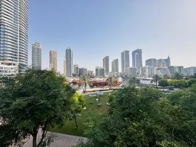 a city skyline with tall buildings and a park at Stylish 1BR Apartment with Marina View, Balcony, Pool & Gym Access in Dubai