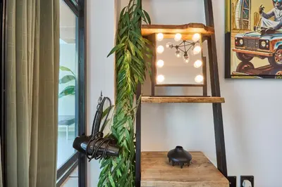 a room with a shelf with a plant and a light at Stylish 1BR Apartment with Pool, Gym & Balcony - JVC Oxford Terraces in Dubai