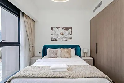 a bedroom with a large bed with a blue headboard at Act One Act Two Stylish 1BR Near Burj Khalifa & Fountains in Dubai