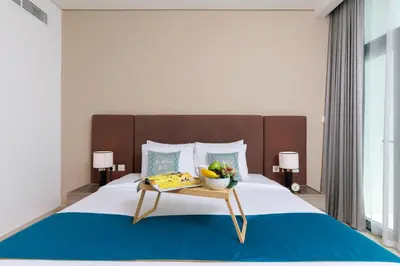 a bed with a table with a bowl of fruit on it at Maison Privee - Elegant Palm Retreat with Iconic Sea & Marina Vws in Dubai