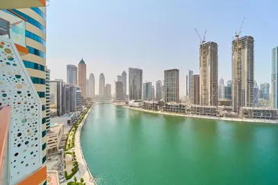 a river in the middle of a city with tall buildings at Modern Studio With Iconic Burj Khalifa & Canal Views in Dubai