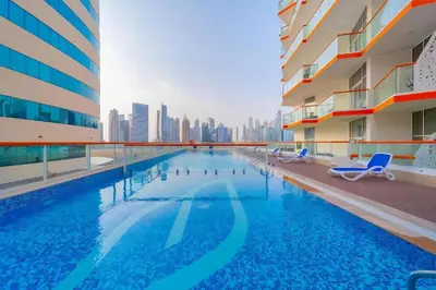 a swimming pool with a city skyline in the background at Modern Studio With Iconic Burj Khalifa & Canal Views in Dubai