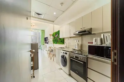 a kitchen with a washer and dryer in it at Modern Studio With Iconic Burj Khalifa & Canal Views in Dubai