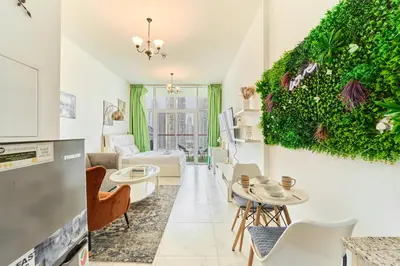 a living room with a kitchen and a living wall at Modern Studio With Iconic Burj Khalifa & Canal Views in Dubai