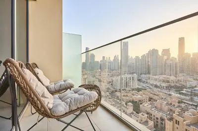 two wicker chairs on a balcony with a view of the city at Luxury 2BR with Balcony, Burj Khalifa View & LED Night Show Downtown in Dubai