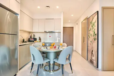 a kitchen and dining room with a table and chairs at Luxury 2BR with Balcony, Burj Khalifa View & LED Night Show Downtown in Dubai