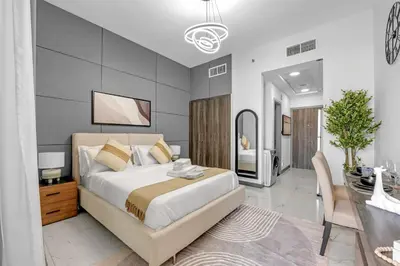 a bedroom with a bed and a dining room at Classy Studio At Rukan in Dubai