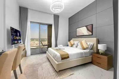a bedroom with a king sized bed and a dining room at Classy Studio At Rukan in Dubai