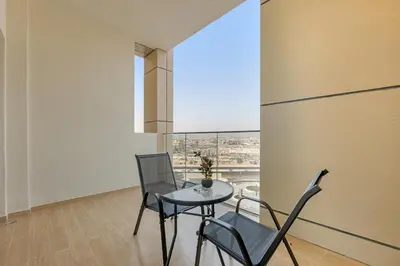 a dining room with a table and chairs and a window at Classy Studio At Rukan in Dubai