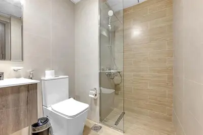 a bathroom with a shower and a toilet and a sink at Classy Studio At Rukan in Dubai