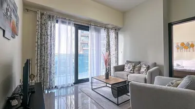 a living room with a couch and a tv at Modern 1BR in Merano, Near Downtown & Burj Khalifa - 14AB07 in Dubai