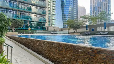 a large swimming pool in a city with tall buildings at Modern 1BR in Merano, Near Downtown & Burj Khalifa - 14AB07 in Dubai
