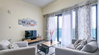 a living room with two couches and a television at Modern 1BR in Merano, Near Downtown & Burj Khalifa - 14AB07 in Dubai