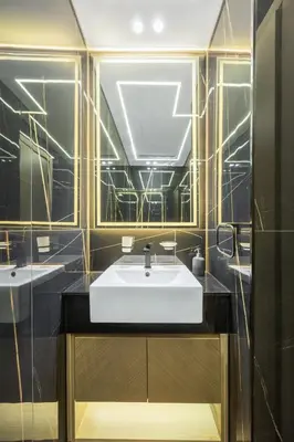 a bathroom with a white sink and black tiles at Modern 1BR in Binghatti Luna, JVC District in Dubai