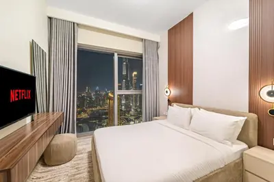 a hotel room with a bed and a large window at Luxury 4BR with full Burj Khalifa and Fountain View - 5Min to Dubai Mall in Dubai